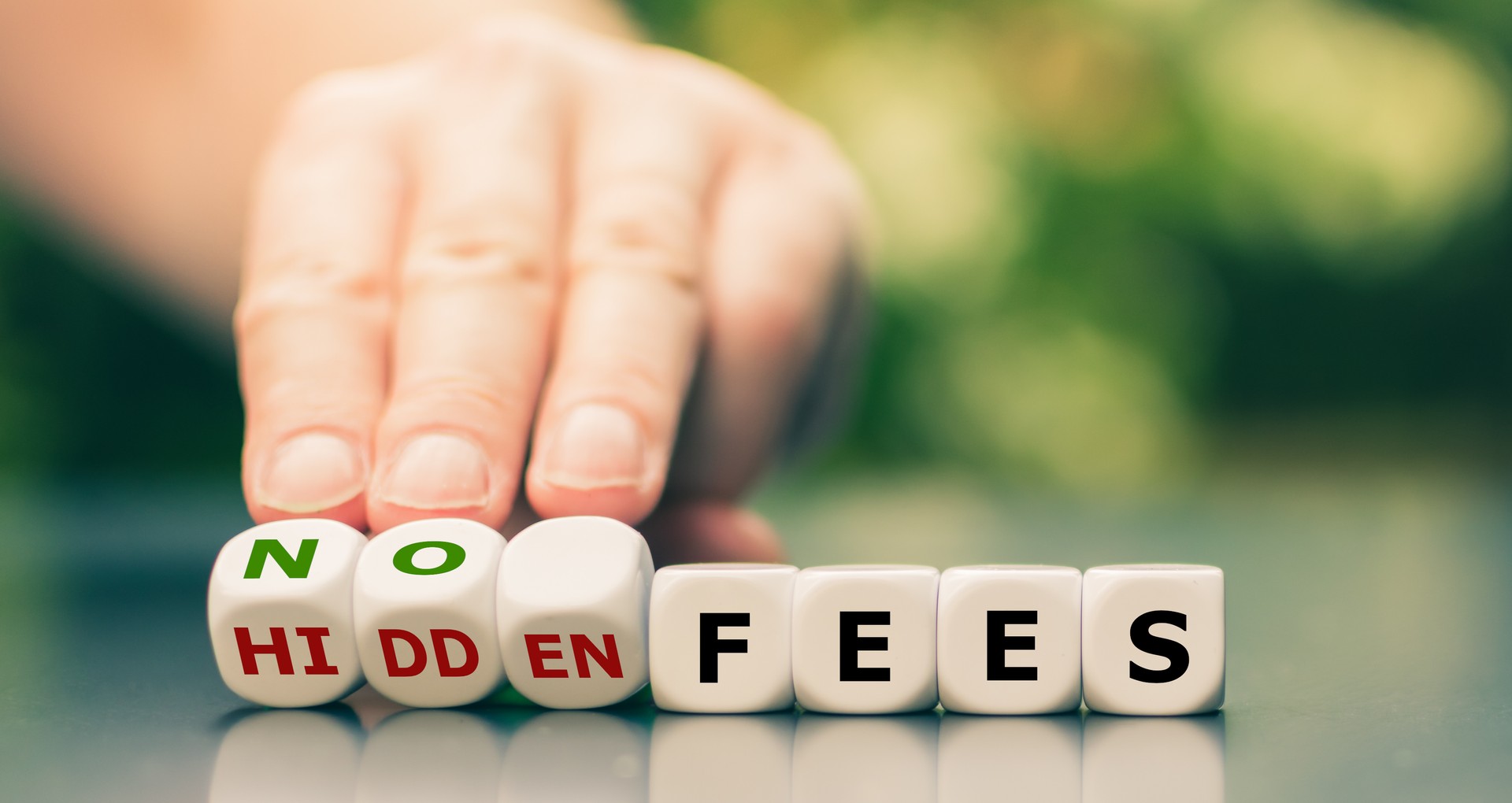 No hidden fees concept. Hand turns dice and changes the expression "hidden fees" to "no fees".